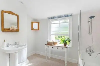 a white bathroom with a sink and a shower at Victorian 2 Bedroom Home near the river Cam in Cambridge