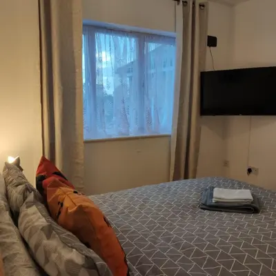 a bedroom with a bed with a large window at Ratcliffe Apartment in Colchester