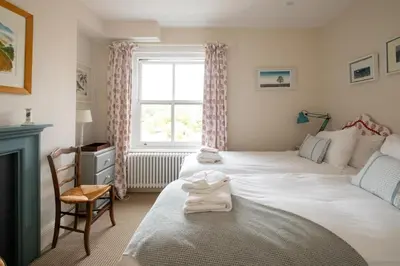 a bedroom with a large white bed and a window at 17 Park Lane, Beautiful 4 bedroom house in the seaside town of Aldeburgh - Maximum occupancy of 7 guests - Aldeburgh Coastal Cottages in Aldeburgh