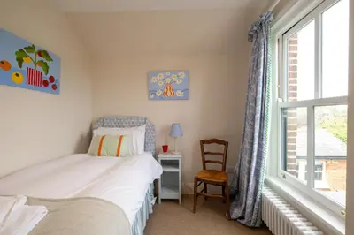 a bedroom with a bed and a window and a chair at 17 Park Lane, Beautiful 4 bedroom house in the seaside town of Aldeburgh - Maximum occupancy of 7 guests - Aldeburgh Coastal Cottages in Aldeburgh
