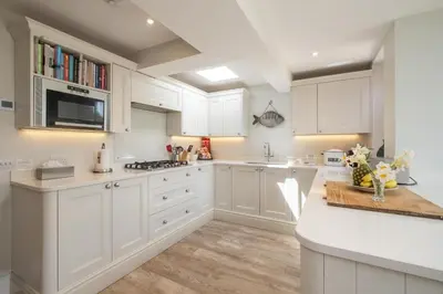a white kitchen with white cabinets and a counter at 17 Park Lane, Beautiful 4 bedroom house in the seaside town of Aldeburgh - Maximum occupancy of 7 guests - Aldeburgh Coastal Cottages in Aldeburgh