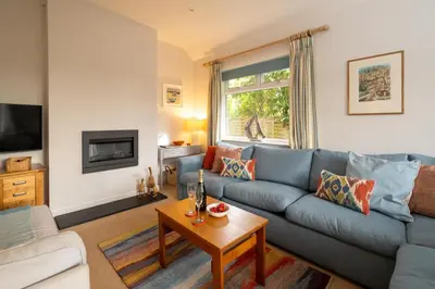 a living room with a blue couch and a table at Pantiles in Aldeburgh