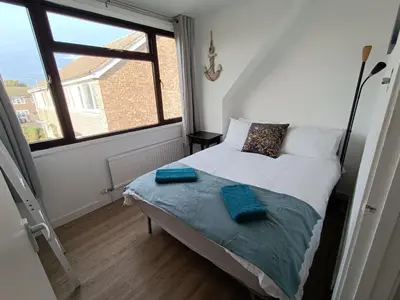 a bedroom with a bed and a large window at Grace's Place in Soham in Soham