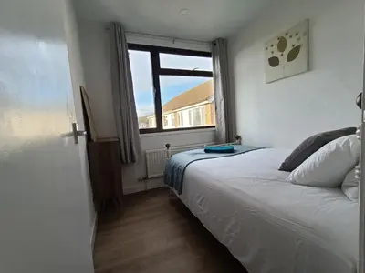 a bedroom with a bed and a large window at Grace's Place in Soham in Soham