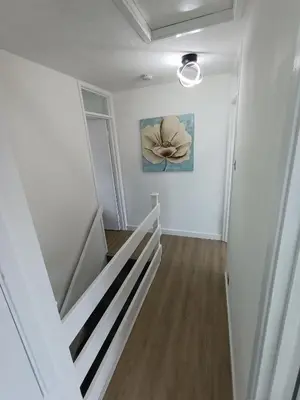 a hallway with a staircase with a painting on the wall at Grace's Place in Soham in Soham