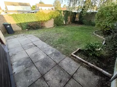 a backyard with a lawn and a garden with a sidewalk at Grace's Place in Soham in Soham