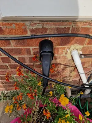 a street light attached to a brick wall with flowers at Luxury on a Budget Chelmsford - B&B ROOM in a quiet family home in Chelmsford