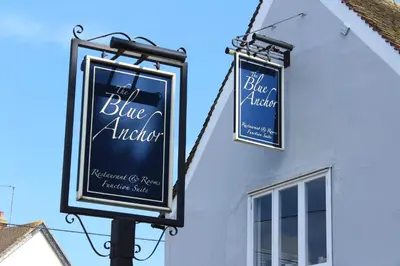 two signs on the side of a building at The Blue Anchor Feering in Colchester