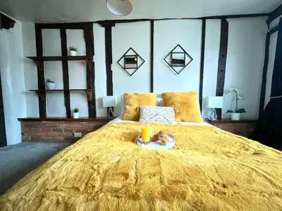 a large bed with a cat on a plate on it at Duchess Apt 1 Serviced 3BR Apartment in Colchester Perfect for Contractors,Temporary Housing, Relocations,Free Wifi, Secure Parking in Colchester