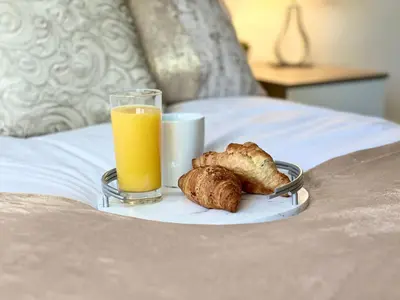 a breakfast plate with a glass of orange juice and bread at Duchess Apt 1 Serviced 3BR Apartment in Colchester Perfect for Contractors,Temporary Housing, Relocations,Free Wifi, Secure Parking in Colchester