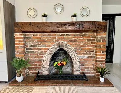a brick fireplace with a vase of flowers on it at Duchess Apt 1 Serviced 3BR Apartment in Colchester Perfect for Contractors,Temporary Housing, Relocations,Free Wifi, Secure Parking in Colchester