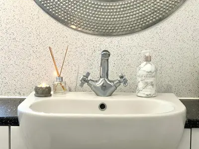 a bathroom sink with a faucet and a mirror at Duchess Apt 1 Serviced 3BR Apartment in Colchester Perfect for Contractors,Temporary Housing, Relocations,Free Wifi, Secure Parking in Colchester