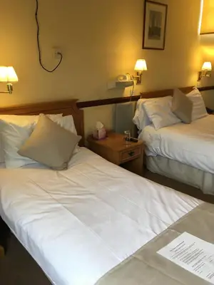 two beds in a hotel room with white sheets at Nyton Hotel in Ely