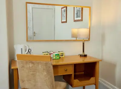 a wooden desk with a lamp and a mirror at Lamb Hotel by Greene King Inns in Ely