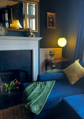 a living room with a blue couch and a fireplace at Elegant Luxury City Centre Apartment on On Mill Rd - Walk to Station and City Centre in Cambridge