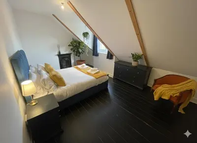 a bedroom with a bed and a stairway with aigunigunigun at Elegant Luxury City Centre Apartment on On Mill Rd - Walk to Station and City Centre in Cambridge
