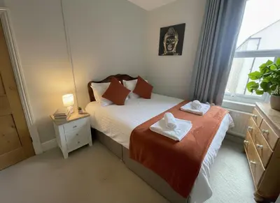a small bedroom with a bed and a window at Elegant Luxury City Centre Apartment on On Mill Rd - Walk to Station and City Centre in Cambridge