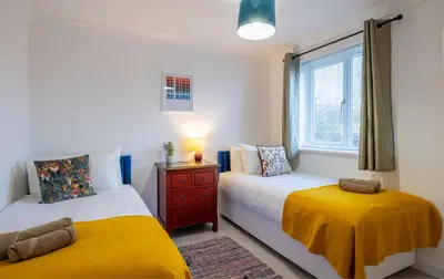 a bedroom with two beds and a window at Award Winning Beautiful House in South Cambridge, 14-Min Drive to the City Centre, Free Parking, No Sofabeds, Sleeps 6 in Cambridge