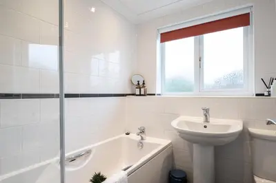 a bathroom with a sink and a bath tub and a toilet at Award Winning Beautiful House in South Cambridge, 14-Min Drive to the City Centre, Free Parking, No Sofabeds, Sleeps 6 in Cambridge
