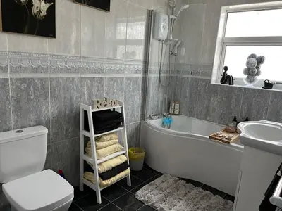 a bathroom with a tub and a toilet and a sink at Rose Garden Retreat in Rayleigh
