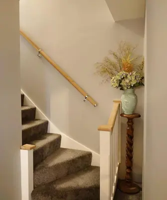 a staircase with a vase of flowers on the wall at Rose Garden Retreat in Rayleigh