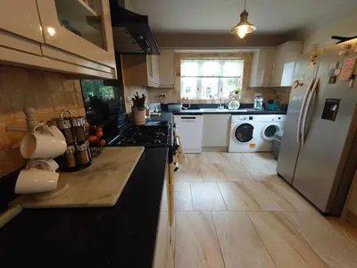 a kitchen with a stove and a refrigerator at Rose Garden Retreat in Rayleigh