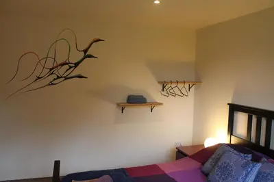 a bedroom with a bed and a shelf on the wall at The Walled Garden in Long Melford