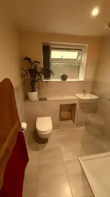 a bathroom with a toilet and a sink and a window at The Walled Garden in Long Melford