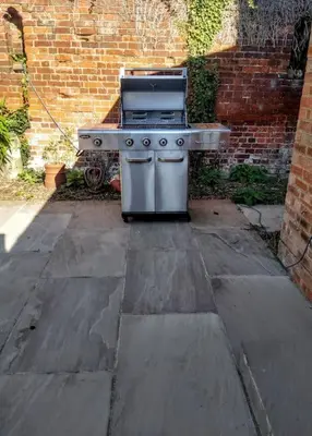 a barbecue grill sitting on a patio next to a brick wall at The Walled Garden in Long Melford