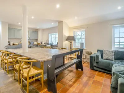 a kitchen and living room with a table and chairs at Abbey Barn Farmhouse in Marham