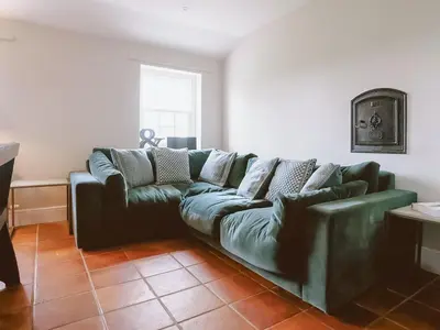 a green couch sitting in a living room at Abbey Barn Farmhouse in Marham