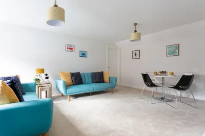a living room with blue chairs and a table at Maldon Executive Apartments in Maldon