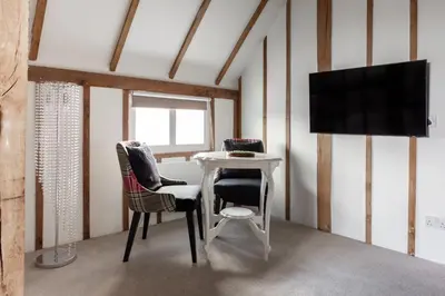 a room with a table and two chairs and a tv at Maldon Executive Apartments in Maldon