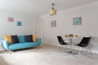 a living room with a blue couch and a table at Maldon Executive Apartments in Maldon
