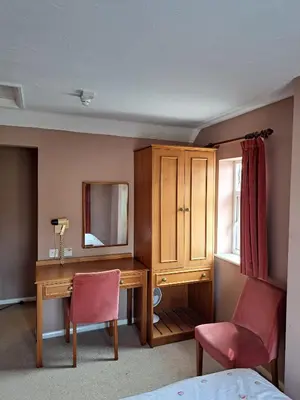 a bedroom with a desk and a mirror at The Prince of Wales in Huntingdon