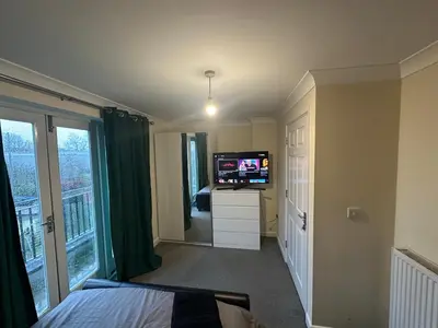 a bedroom with a flat screen tv and a bed at Relaxing double rooms in a beautiful house in Ipswich