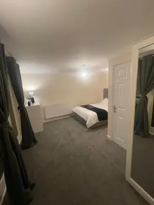 a small bedroom with a bed and a door at Relaxing double rooms in a beautiful house in Ipswich