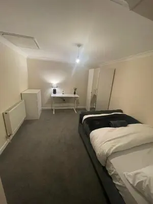 a bedroom with two beds and a desk in it at Relaxing double rooms in a beautiful house in Ipswich