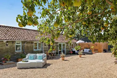 a patio with couches and chairs in front of a house at 3 Bed in Sedge Fen oc-b28087 in Lakenheath