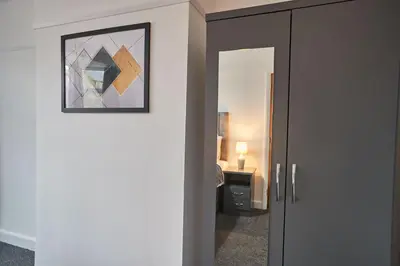 a door to a bedroom with a picture on the wall at Elfleda Stay - Modern 5 bedroom house with parking in Cambridge
