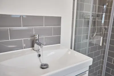 a bathroom with a sink and a shower at Elfleda Stay - Modern 5 bedroom house with parking in Cambridge