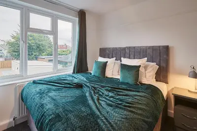 a bedroom with a bed with a large window at Elfleda Stay - Modern 5 bedroom house with parking in Cambridge