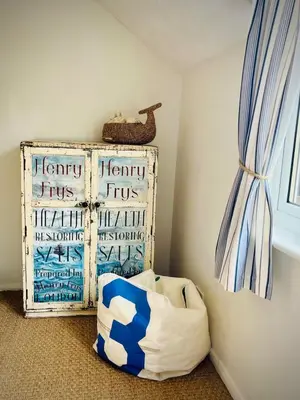 a corner of a room with a pillow and a window at Gorgeous Comfy Cottage Walking Birdwatching Paddle Boarding and Seafood on the Doorstep in West Mersea