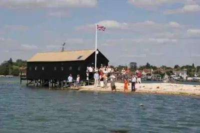 a group of people standing on a building in the water at Gorgeous Comfy Cottage Walking Birdwatching Paddle Boarding and Seafood on the Doorstep in West Mersea