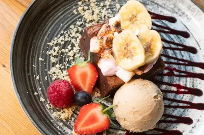 a plate of food with fruit and ice cream at The Red Lion in East Bergholt