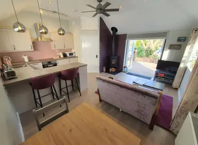 a kitchen and living room with a couch and a table at River Cottage in Stoke Ferry