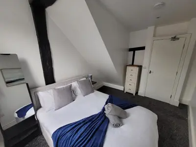 a bedroom with a bed with a stuffed animal on it at City Centre Wallgate Apartments- Step back into Roman history in Colchester