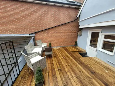 an outdoor deck with stairs and a brick building at City Centre Wallgate Apartments- Step back into Roman history in Colchester