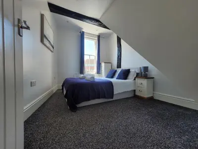 a bedroom with a bed and a window at City Centre Wallgate Apartments- Step back into Roman history in Colchester