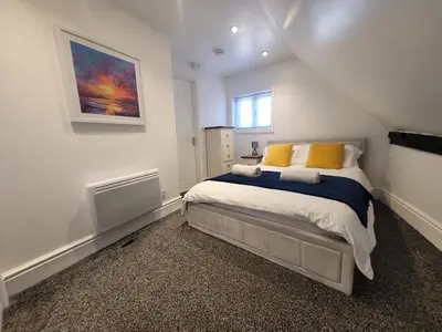 a bedroom with a large bed with yellow pillows at City Centre Wallgate Apartments- Step back into Roman history in Colchester